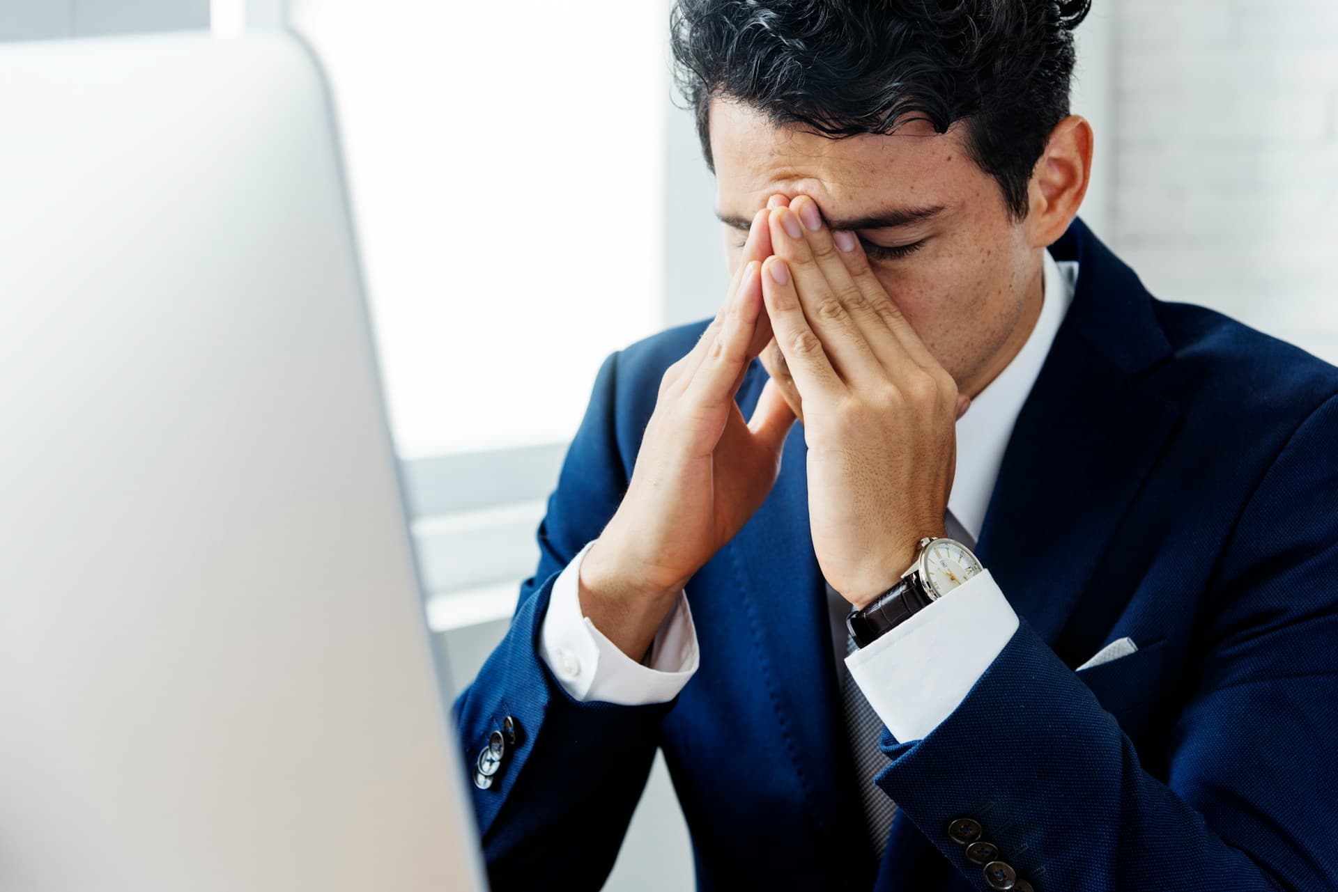 businessman holding his hands to his face. 