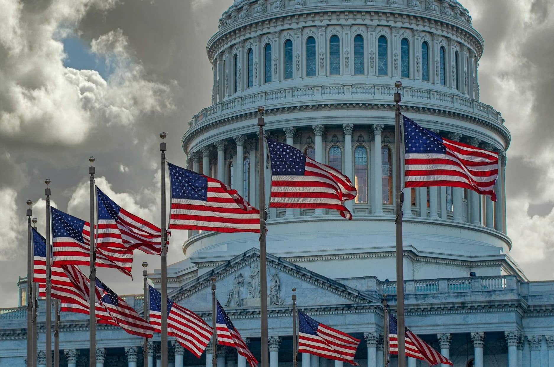 Picture of the US Capitol Building with American flags in front of it.