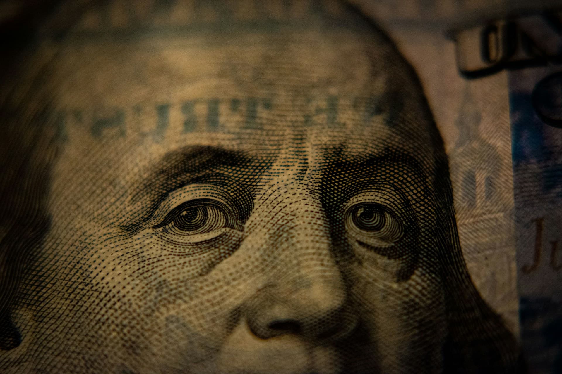 Dark image of a hundred-dollar bill. 