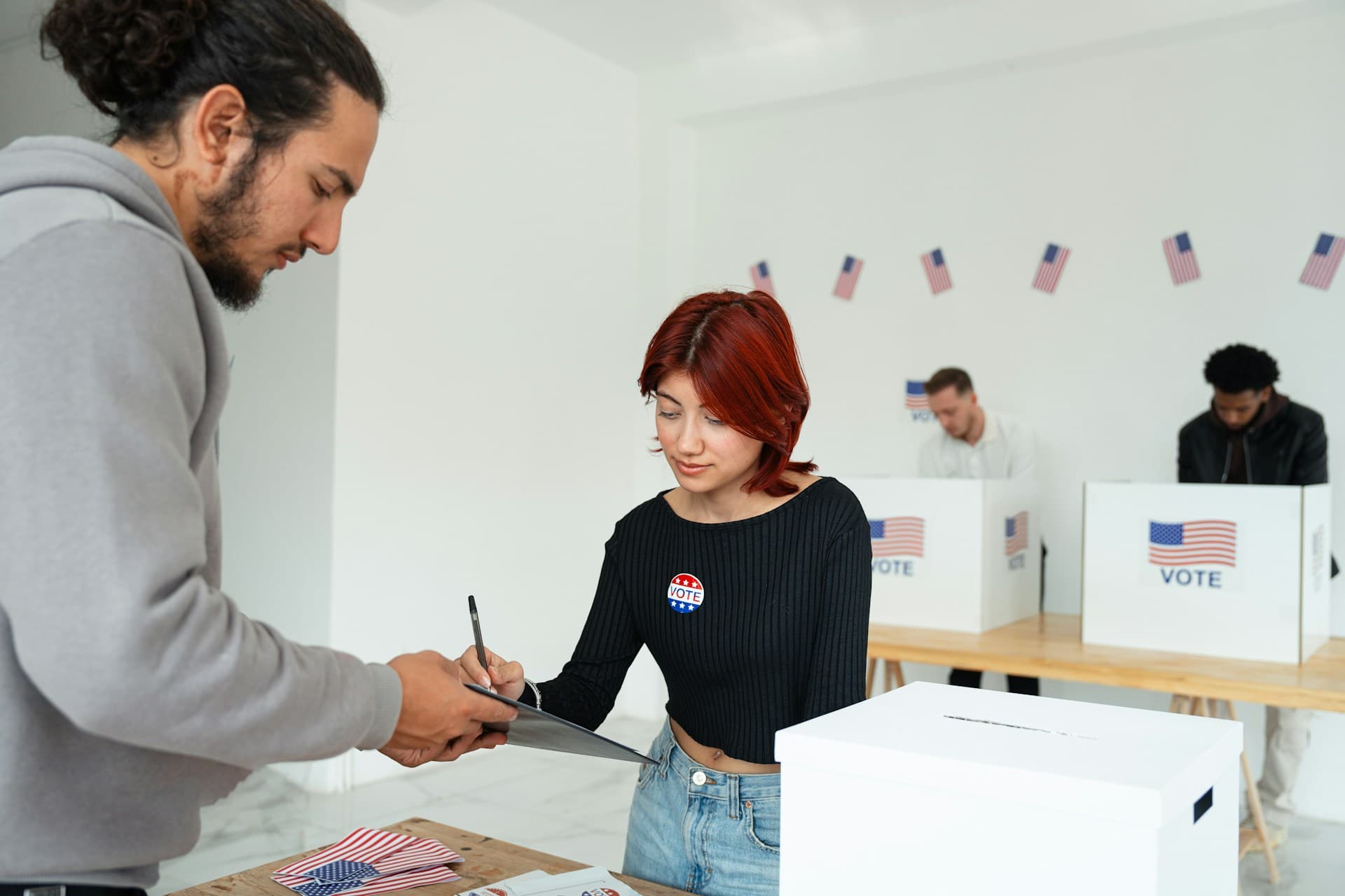 A poll worker helping someone vote. 