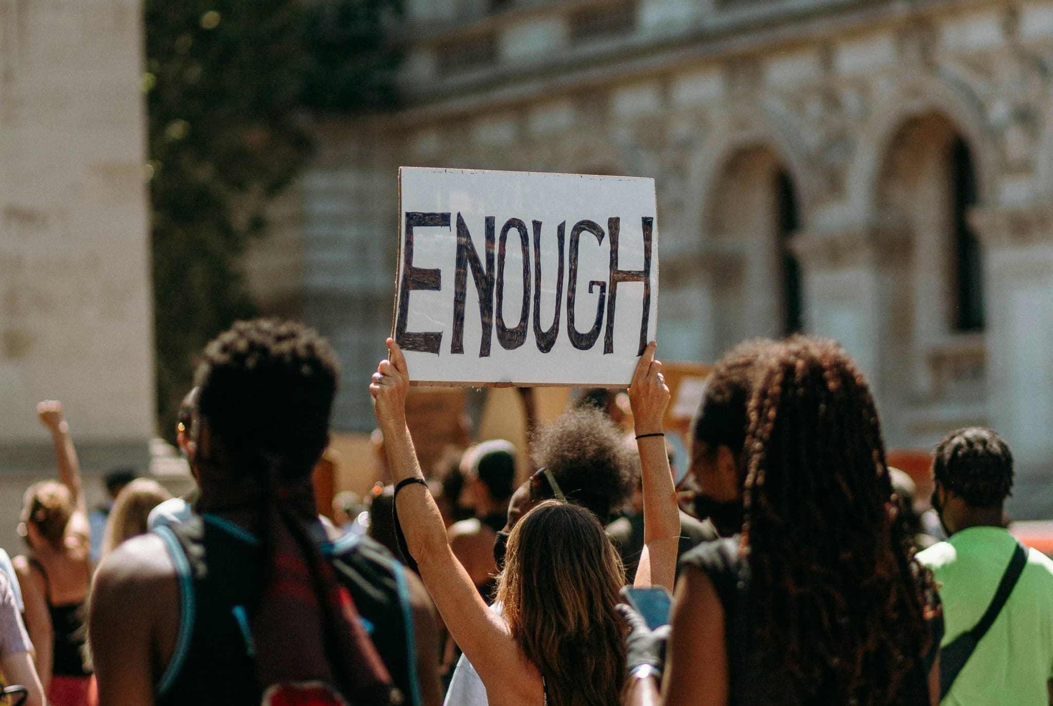 Protesters holding up a sign that says enough. 